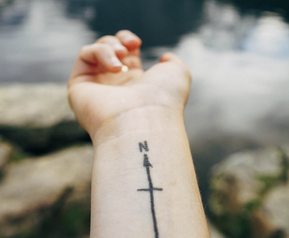 fotografía de tatuaje en antebrazo señalando al norte